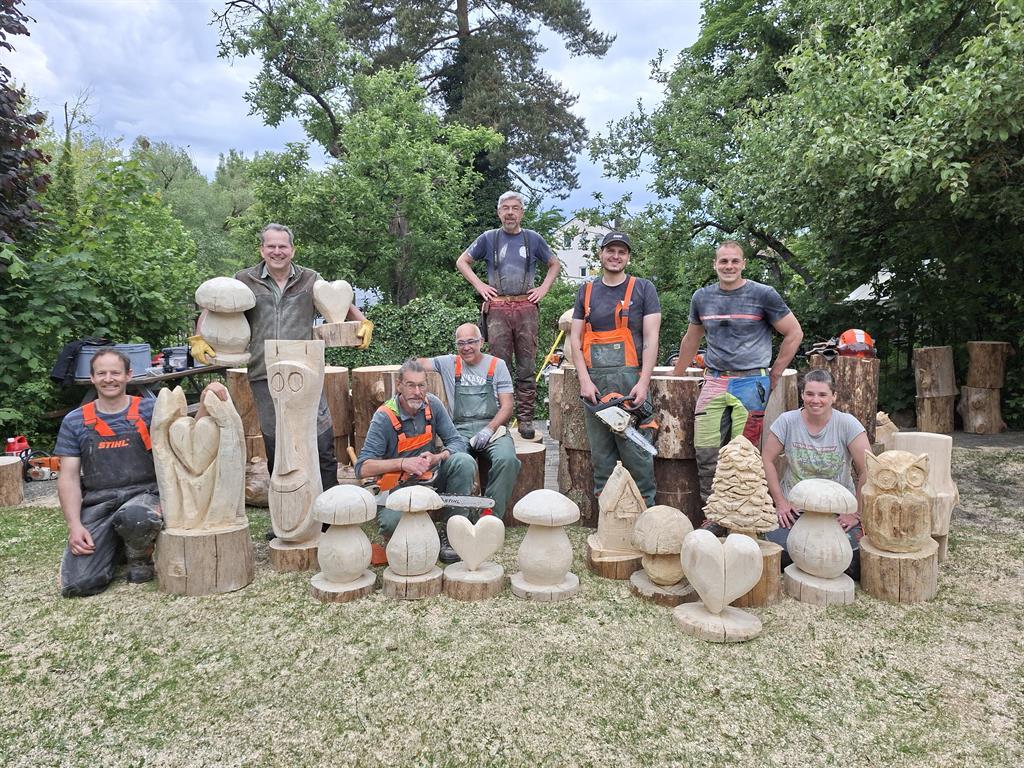 Gruppenfoto der Schnitzer:innen und ihrer Werke.